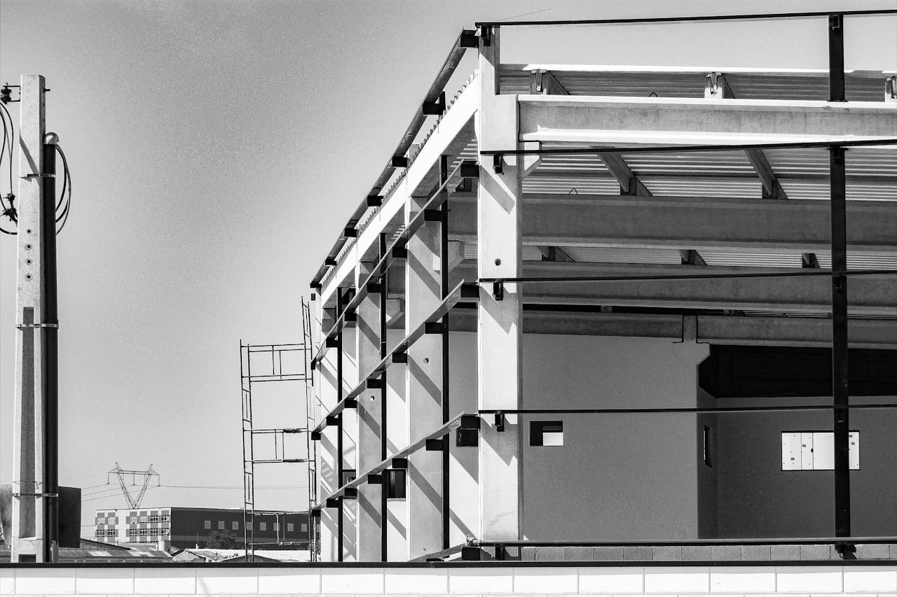 Black and white image of a modern building construction site with steel framework.